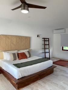 um quarto com uma cama grande e uma ventoinha de tecto em Luana suites- Suite Koya em Zihuatanejo