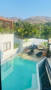 a swimming pool with a view of a house at Luana suites- Suite Koya in Zihuatanejo