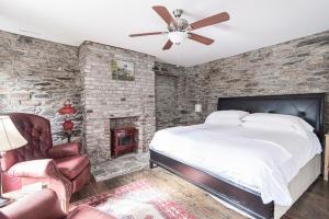 a stone walled bedroom with a bed and a fireplace at Light Horse Inn in Harpers Ferry