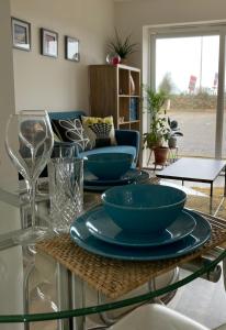 a glass table with three blue bowls on top of it at Dog Friendly Stylish Modern Flat, near Beach in Newquay