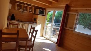 a kitchen and dining room with a table and a window at CHALETS Climatisés in Salernes