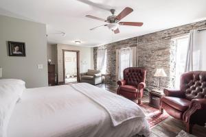 a bedroom with a bed and two chairs at Light Horse Inn in Harpers Ferry