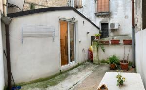 mały biały budynek z drzwiami i doniczkami w obiekcie Casa vacanze Umberto I w mieście Ascoli Satriano