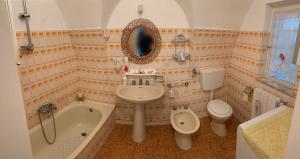 łazienka z umywalką, wanną i toaletą w obiekcie Casa vacanze Umberto I w mieście Ascoli Satriano