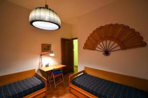 um quarto com duas camas, uma mesa e um candeeiro em MareMonti em Marinella di Sarzana