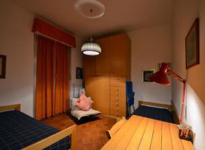 um quarto com 2 camas e um candeeiro vermelho em MareMonti em Marinella di Sarzana