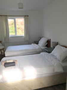 Duas camas num quarto com uma janela em Cree River Cottage em Creegh