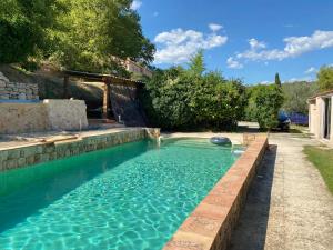 a swimming pool in a backyard with a retaining wall at CHALETS Climatisés in Salernes