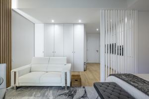 Un dormitorio con una silla blanca y una cama en Apartamento Vista Mar en Canidelo