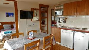 una cucina e una sala da pranzo con tavolo e una camera con letto di Superbe appartement Chamrousse près des pistes a Chamrousse