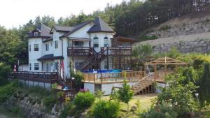 ein großes weißes Haus mit einer großen Terrasse auf dem Wasser in der Unterkunft Another world pension in Gyeongju