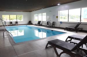 einen großen Pool mit Stühlen und einem Tisch in der Unterkunft Comfort Inn & Suites in Cave City