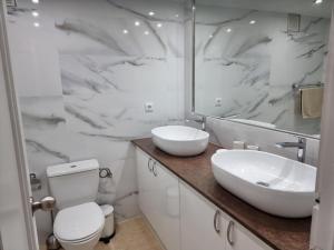 y baño con lavabo, aseo y espejo. en La Manga Resort Bellaluz 01-19, en Atamaría