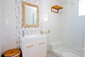 a bathroom with a sink and a mirror and a tub at Apartamento SofiSara in Tavira