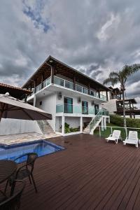une maison avec une terrasse et une piscine dans l'établissement Vista Espetacular em Escarpas com Piscina, à Capitólio
