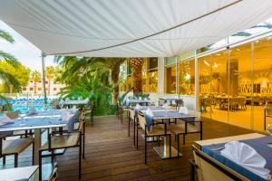 a restaurant with tables and chairs on a deck at Estival Park Silmar in La Pineda