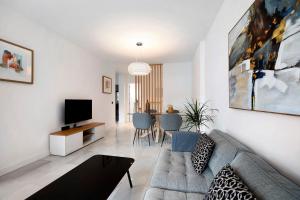 a living room with a couch and a tv at MARIA DEL MAR SEA APARTMENT in Chiclana de la Frontera