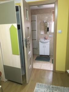 La salle de bains est pourvue d'un lavabo blanc et d'une douche. dans l'établissement Kwatery Prywatne u Gosi nad Soliną, à Solina