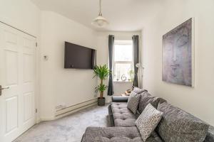 ein Wohnzimmer mit einem Sofa und einem Flachbild-TV in der Unterkunft Charming 1 Bedroom Apartment - Edinburgh in Edinburgh