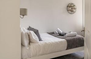 - une chambre avec un lit doté de draps et d'oreillers blancs dans l'établissement Charming 1 Bedroom Apartment - Edinburgh, à Édimbourg
