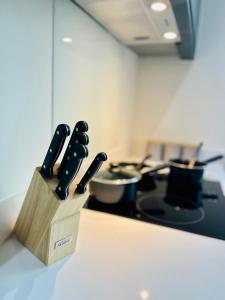 Um bloco de facas com seis facas sentadas no balcão da cozinha. em Stylish studio apartment near to Old Trafford stadium em Manchester