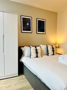 um quarto com uma grande cama branca com almofadas em Stylish studio apartment near to Old Trafford stadium em Manchester