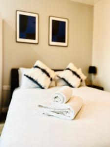 een slaapkamer met 2 handdoeken op een wit bed bij Stylish studio apartment near to Old Trafford stadium in Manchester