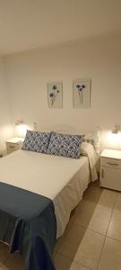a bedroom with a large bed with blue and white pillows at ALOJAMIENTO LA ESTACIÓN in Gualeguaychú