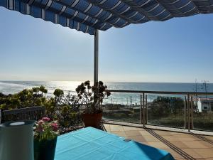 a view of the ocean from a patio with a table at Mega Ocean Magoito - Sintra in Sintra