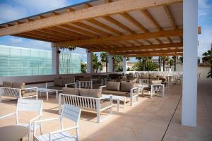 eine Terrasse mit Stühlen, Tischen und einer Bar in der Unterkunft Estival Park Silmar in La Pineda