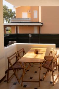 un tavolo in legno e 2 sedie sul balcone di Capitana Home Stay a Costa degli Angeli