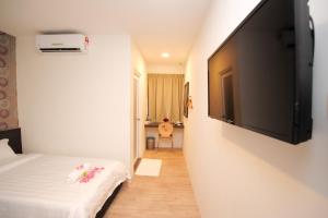 a room with a bed and a flat screen tv at Hotel Mezzo in Kuala Lumpur