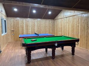 a pool table in a room with wooden walls at Atulyam, Pangot in Nainital