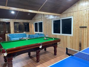 a billiard room with a pool table and couches at Atulyam, Pangot in Nainital