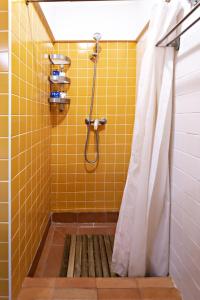 タヴィラにあるYellow Stripeのバスルーム(イエロータイル張りのシャワー、シャワーカーテン付)