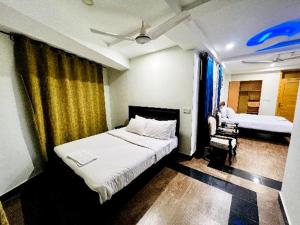 1 dormitorio con 1 cama y 1 silla en una habitación en AAKAS HOTEL & RESTAURANT en Muzaffarabad