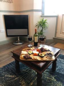 uma mesa com um prato de comida e uma garrafa de vinho em *Stunning* The Botanist Rest Ventnor IOW em Ventnor