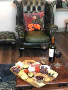 uma mesa com um prato de comida e dois copos de vinho em *Stunning* The Botanist Rest Ventnor IOW em Ventnor
