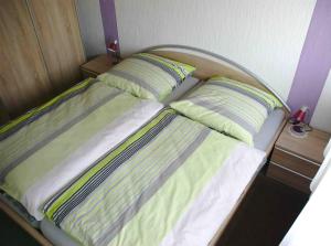 ein Bett mit zwei Kissen auf einem Zimmer in der Unterkunft Behringer in Immenstaad am Bodensee