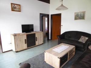 ein Wohnzimmer mit einem Sofa, einem TV und einem Tisch in der Unterkunft Behringer in Immenstaad am Bodensee