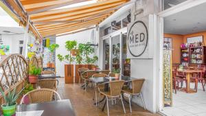 un restaurant avec des tables et des chaises et un panneau sur le mur dans l'établissement Great Escape, Golf del Sur, à San Miguel de Abona