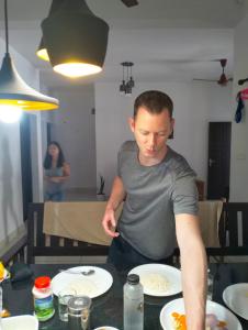 a man standing at a table preparing food at Bachan's Casa in Cherai Beach