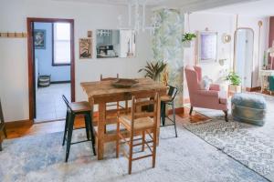 a living room with a wooden table and chairs at Bohemian Compound with Hot Tub in Winooski