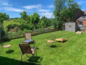 a yard with chairs and a table and a bench at Bohemian Compound with Hot Tub in Winooski