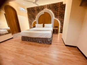 um quarto com uma cama num quarto com piso em madeira em Hotel Nova Bopal em Bodakdev