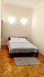 um quarto com uma cama com um tapete e duas luzes em Центр Свободи em Lviv