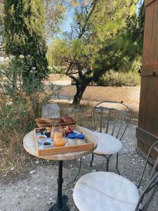 una mesa con una bandeja de comida y dos sillas en Chambre d'hôtes dans une ancienne bergerie, en Les Angles