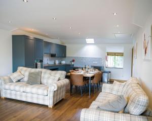 a kitchen and living room with two couches and a table at The Old Stables at Castle Chase, Ayston in Uppingham