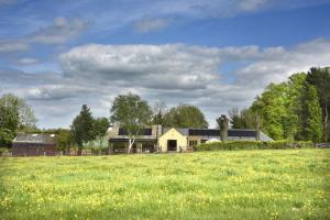 ein Haus auf einem Feld mit Gras in der Unterkunft The Old Stables at Castle Chase, Ayston in Uppingham