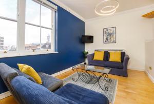 uma sala de estar com paredes azuis e um sofá em William Morris on the historic Shambles York em York
